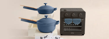 Blue cookware set with a black oven on a beige background