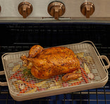 A whole roasted chicken sits on a wire rack above chopped vegetables in a baking pan inside an oven, with oven control knobs visible at the top.