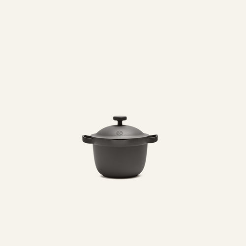 The Petite Perfect Pot, a matte black nonstick pot with two side handles ideal for personal servings, is centered against a plain light background.