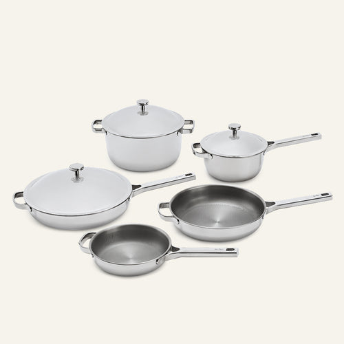A Titanium Pro Cookware Set+ consisting of five stainless steel pieces, including three pans with matching lids and two open skillets.