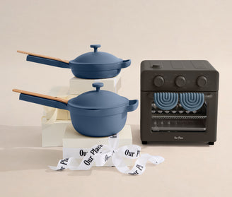 Blue cookware set with a black oven on a beige background