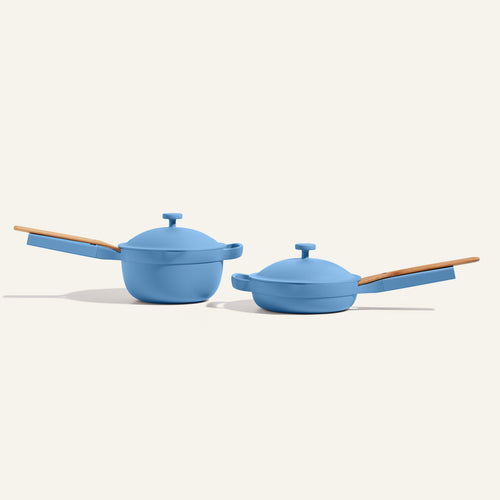 Two blue pots with wooden handles on a white background