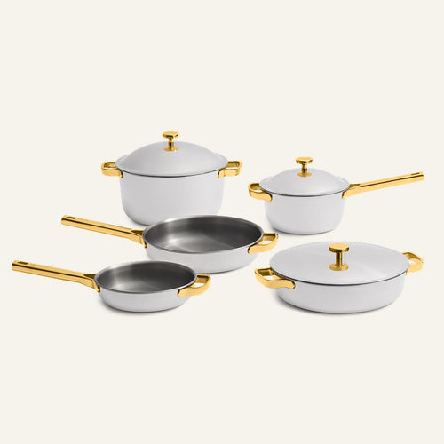 Titanium Pro Cookware Set + Braiser Pro: five pieces of white titanium cookware with metallic gold handles and lids, including a stockpot, a saucepan, two skillets, and a braiser.