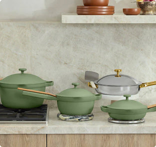 Set of green cookware on a kitchen counter with a neutral background