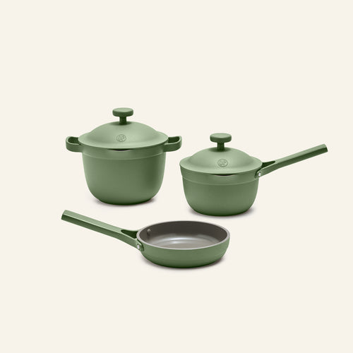 The Tiny Cookware Duo + Petite Perfect Pot, featuring a green nonstick frying pan, saucepan with lid, and stockpot with lid, are displayed against a plain light background.